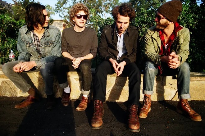 Group shot of the band Dawes, seated outdoors