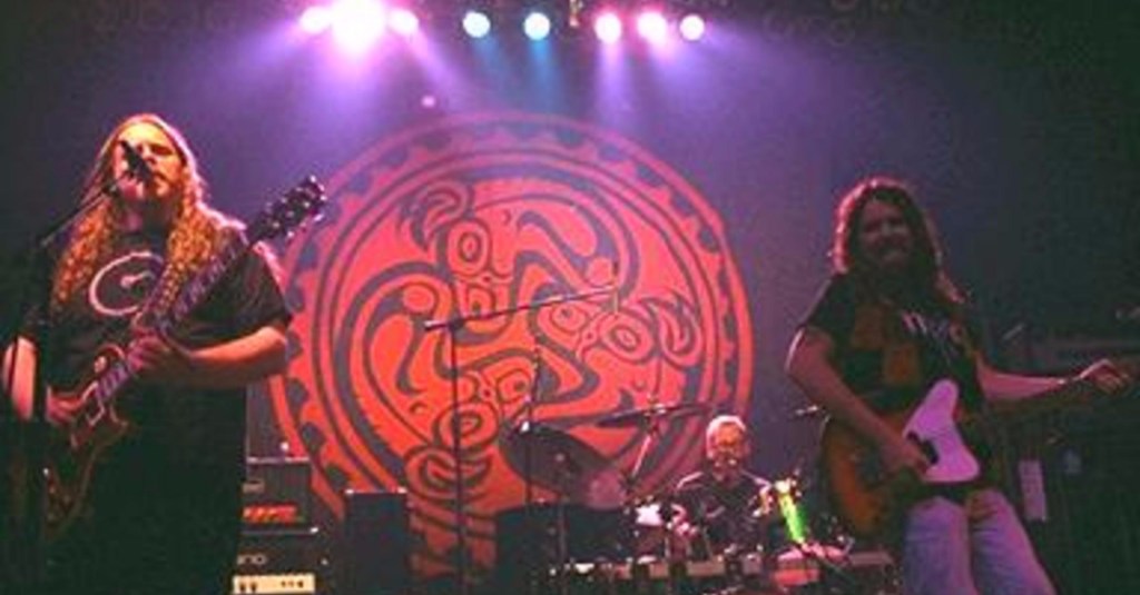 Gov't Mule on stage in front of Dose logo banner