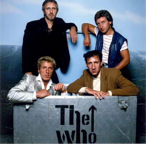 The Who group shot standing behind tour crates.
