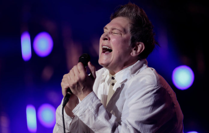 Singer k.d. lang emotionally singing and holding microphone