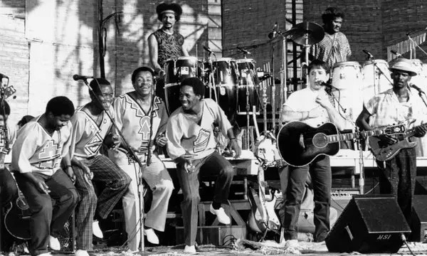 Paul Simon on stage with band during Graceland tour.