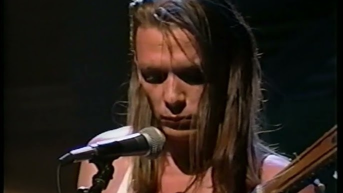 Close-up shot of singer and guitarist Chris Whitley in front of microphone.