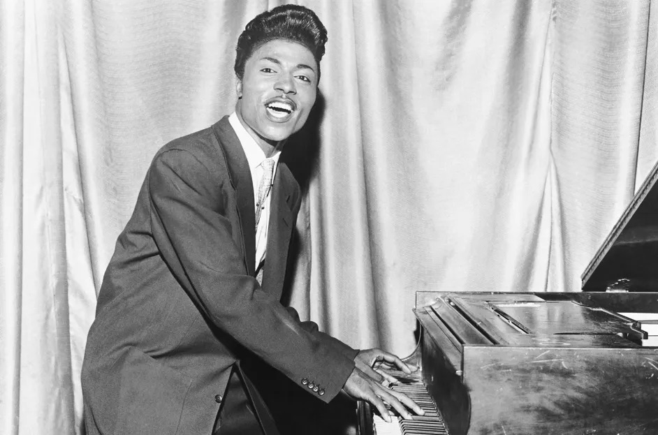 Little Richard standing at piano playing and singing