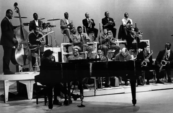 Count Basie at piano with his Orchestra behind him