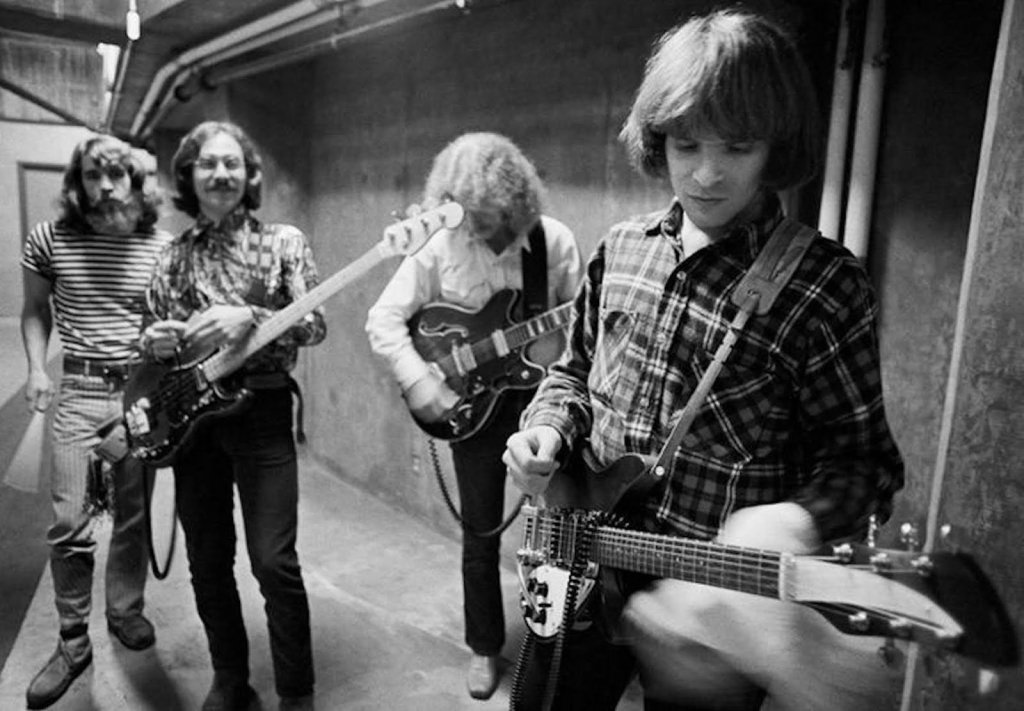 Group shot of the band CCR holding various guitars