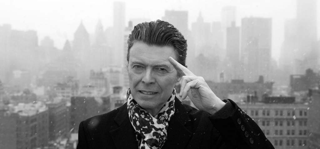 David Bowie 2016 outdoors on rooftop with hand on head in salute like pose
