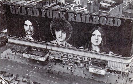 A large mural / billboard in Times Square featuring the band Grand Funk Railroad
