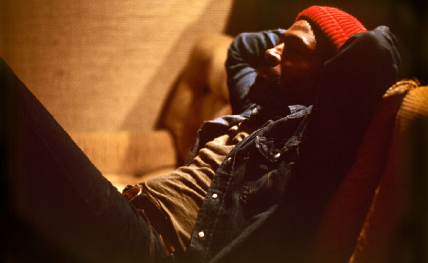 Marvin Gaye relaxing on couch with hands behind head