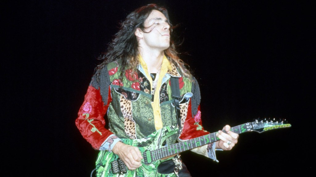 Steve Vai with multi-colored shirt and multi-colored guitar
