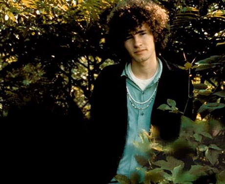 Tim Buckley outdoors by green trees