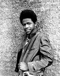Singer Al Green standing in front of a brick wall.