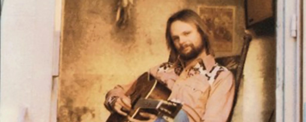 Singer Jonathan Edwards sitting with an acoustic guitar in his hands