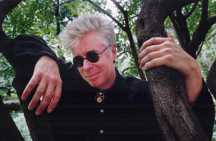 Singer / Guitarist Bruce Cockburn outside by tree