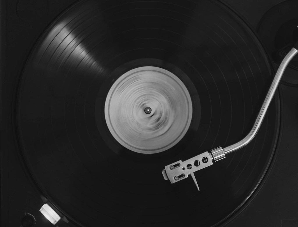 Image of an album on a turntable with the arm / stylus playing