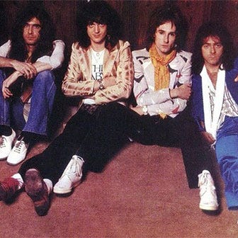 Group shot of the band The Babys 1977 seated on the floor.