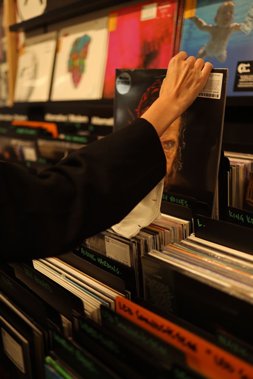 photo of a person s hand picking a vinyl record